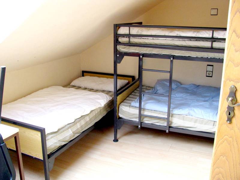 Schlafzimmer mit Einzelbett und Etagenbett im Freizeitheim Forsthaus.